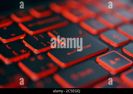 Red backlit computer keyboard macro shot of enter key Stock Photo