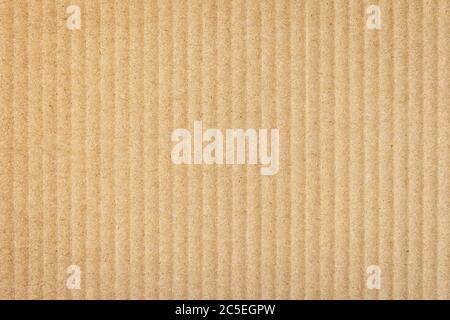 Paper cardboard background. Natural corrugated carton sheet. Kraft cardboard texture with vertical stripes. Seamless light brown paperboard for backgr Stock Photo