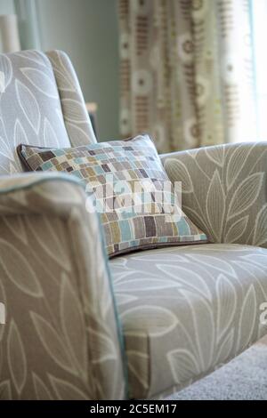 Shot of multi-colored pillows on arm chair in modern living room Stock Photo