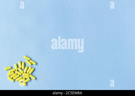 Yellow capsules on a blue background. Omega-3 vitamins. food Supplement. Fish oil in capsules. Free space. space for text. copy space. blurred backgro Stock Photo