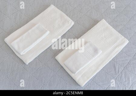 Terry towels on the bed, clean, white, neatly folded. Close-up. Stock Photo
