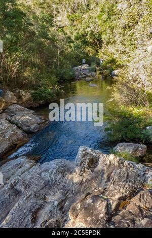 Top of the Belchior waterfall, overlooking its lake between rocks and large forest, santuario do caraca, city of Catas Altas, state of Minas Gerais, B Stock Photo