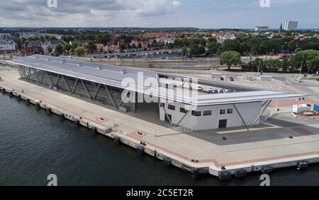 02 July 2020, Mecklenburg-Western Pomerania, Warnemünde: The new cruise terminal "Warnemünde Cruise Center 8" will be presented at a press event. The 15 million euro terminal extends the existing cruise port of the Baltic Sea resort. (Aerial view with a drone/helicopter) Photo: Bernd Wüstneck/dpa-Zentralbild/ZB Stock Photo