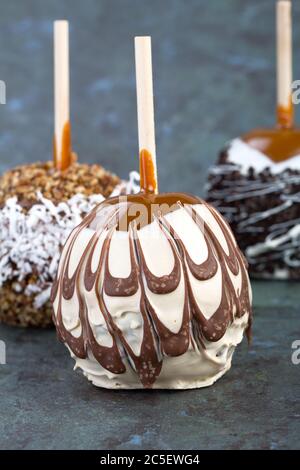 A trio of coated candy apples over slate background Stock Photo