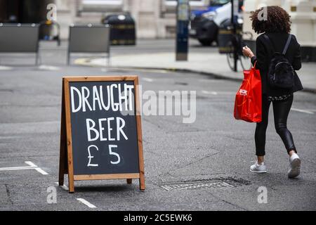London, UK.  2 July 2020.  A sandwich board advertises draught beer on sale for takeaway at a restaurant in Covent Garden.  The UK government will allows pubs to reopen on 4 July as further coronavirus pandemic lockdown restrictions are relaxed.  Critics have said that a more cautios reopening for pubs should take place, on a Monday instead of a Saturday. Credit: Stephen Chung / Alamy Live News Stock Photo