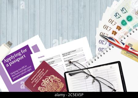 English violet guide Applying for a passport lies on table with office items. UK passport paperwork process Stock Photo