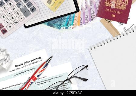 English Tax form sa107 Capital gains summary from HM revenue and customs lies on table with office items. HMRC paperwork and tax paying process in Uni Stock Photo