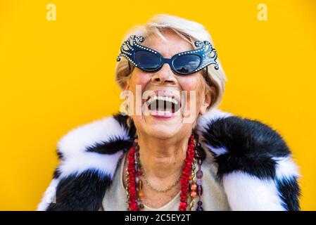 Happy and playful senior woman having fun - Portrait of a beautiful lady above 70 years old with stylish clothes, concepts about senior people Stock Photo