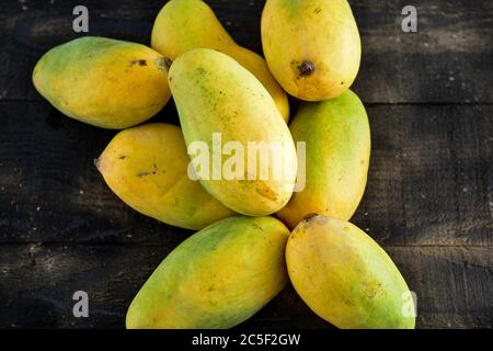 fresh mangoes on black wooden  background Stock Photo