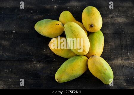 fresh mangoes on black wooden  background Stock Photo