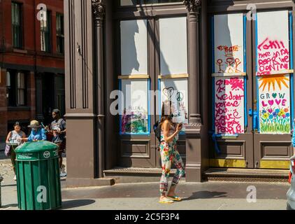 Artists decorate the plywood covering many of the stores in Soho in New York that were looted or vandalized during the protests related to the death of George Floyd, seen on Saturday, June 20, 2020. The city enters Phase Two of its reopening on June 22 and many of the boarded up stores will remove the wood and the artwork will be stored and preserved for a future exhibition. (© Richard B. Levine) Stock Photo