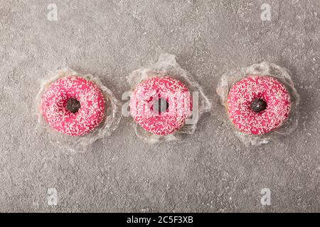 Donuts with pink cream strawberry bagels, top view Stock Photo