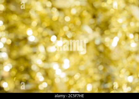 Abstract yellow bright sparkling background, defocused christmas lights. Blurred background for holidays and parties. Stock Photo