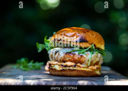 Pork and chorizo burger with cheese in brioche bun Stock Photo