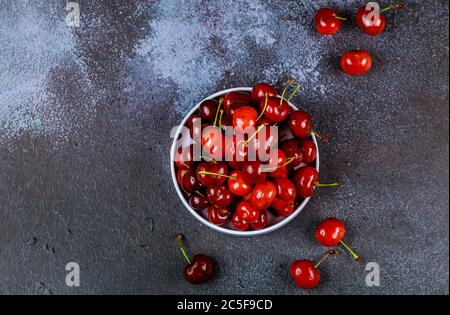 Organic sour cherries with stem in plate on dark background. Stock Photo