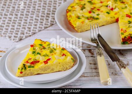 Piece of cauliflower omelette with fork and knife on white wooden background. Stock Photo