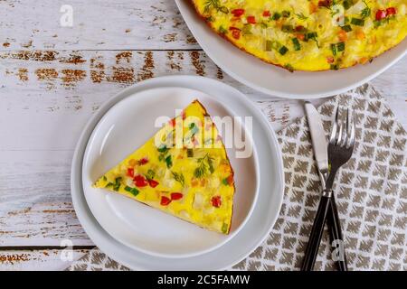 Colorful scrambled eggs with vegetables on white plate. Top view. Stock Photo