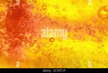 Abstract textured gel background. Yellow and orange liquid with bubbles. Soft focus macro shot. Stock Photo