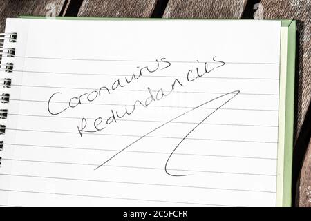 CORONAVIRUS REDUNDANCIES written on lined paper Stock Photo