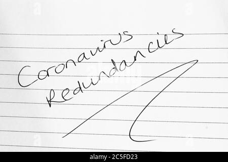 CORONAVIRUS REDUNDANCIES written on lined paper Stock Photo