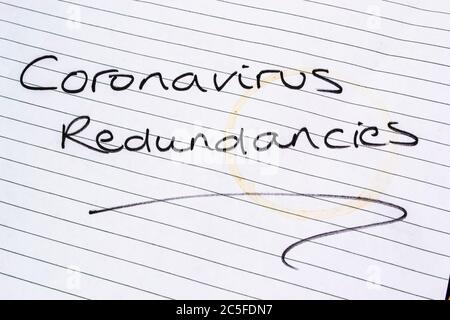 CORONAVIRUS REDUNDANCIES written on lined paper Stock Photo
