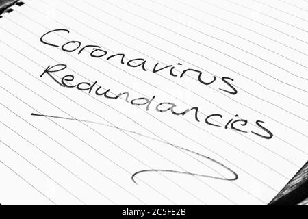 CORONAVIRUS REDUNDANCIES written on lined paper Stock Photo
