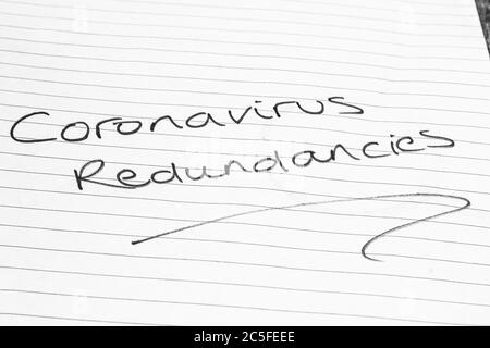 CORONAVIRUS REDUNDANCIES written on lined paper Stock Photo