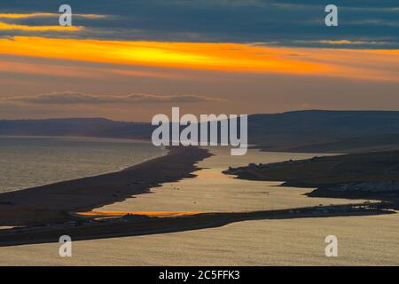 Isle of Portland, Dorset, UK.  2nd July 2020.  UK Weather.  Sunset viewed from the Isle of Portland in Dorset looking along Chesil Beach and The Fleet lagoon on the Jurassic Coast.  Picture Credit: Graham Hunt/Alamy Live News Stock Photo