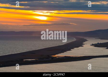 Isle of Portland, Dorset, UK.  2nd July 2020.  UK Weather.  Sunset viewed from the Isle of Portland in Dorset looking along Chesil Beach and The Fleet lagoon on the Jurassic Coast.  Picture Credit: Graham Hunt/Alamy Live News Stock Photo