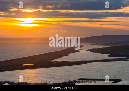 Isle of Portland, Dorset, UK.  2nd July 2020.  UK Weather.  Sunset viewed from the Isle of Portland in Dorset looking along Chesil Beach and The Fleet lagoon on the Jurassic Coast.  Picture Credit: Graham Hunt/Alamy Live News Stock Photo