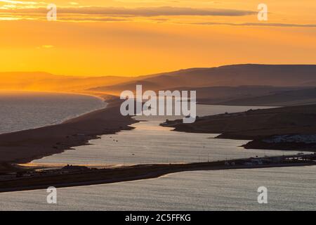 Isle of Portland, Dorset, UK.  2nd July 2020.  UK Weather.  Sunset viewed from the Isle of Portland in Dorset looking along Chesil Beach and The Fleet lagoon on the Jurassic Coast.  Picture Credit: Graham Hunt/Alamy Live News Stock Photo