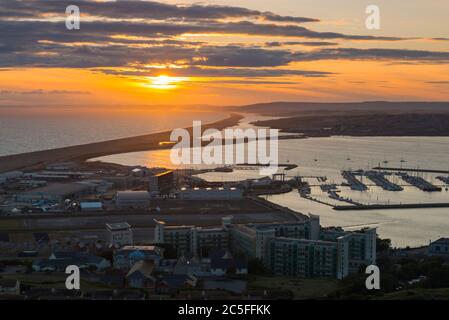 Isle of Portland, Dorset, UK.  2nd July 2020.  UK Weather.  Sunset viewed from the Isle of Portland above Castletown in Dorset looking along Chesil Beach and The Fleet lagoon on the Jurassic Coast.  Picture Credit: Graham Hunt/Alamy Live News Stock Photo