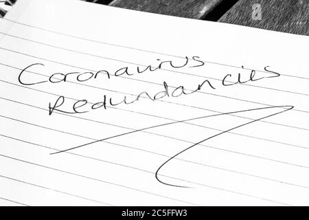 CORONAVIRUS REDUNDANCIES written on lined paper Stock Photo