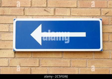 One-way street road sign on anyellow brick wall. Stock Photo