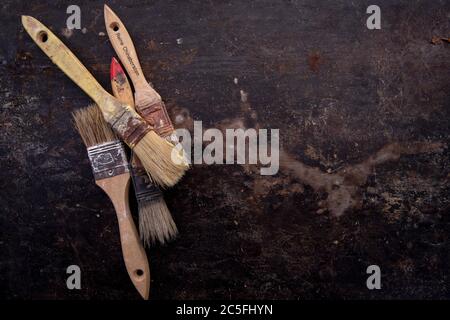 old tools, hammer, chisel, spatula measuring tape and brushes greasy and dirty heavily rusted lie on a metal dark background Stock Photo
