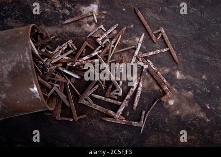 old nuts, screws and nails greasy and dirty heavily rusted lie on a metal dark background Stock Photo