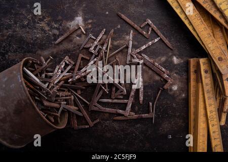 old nuts, screws and nails greasy and dirty heavily rusted lie on a metal dark background Stock Photo