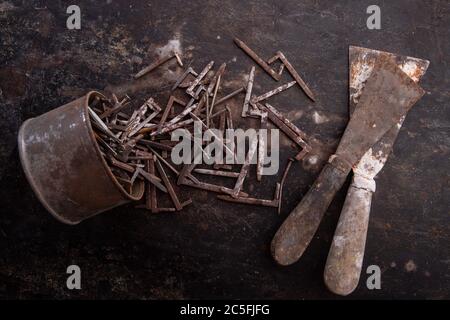 old nuts, screws and nails greasy and dirty heavily rusted lie on a metal dark background Stock Photo