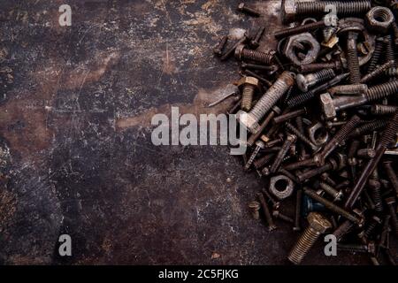 old nuts, screws and nails greasy and dirty heavily rusted lie on a metal dark background Stock Photo