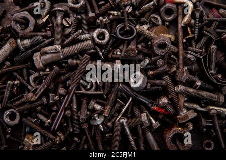 old nuts, screws and nails greasy and dirty heavily rusted lie on a metal dark background Stock Photo
