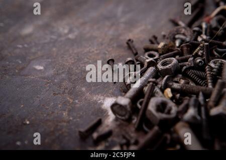 old nuts, screws and nails greasy and dirty heavily rusted lie on a metal dark background Stock Photo