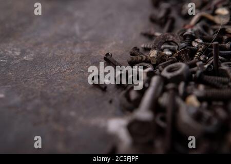 old nuts, screws and nails greasy and dirty heavily rusted lie on a metal dark background Stock Photo