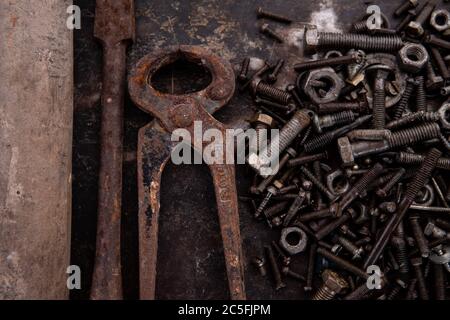 old nuts, screws and nails greasy and dirty heavily rusted lie on a metal dark background Stock Photo