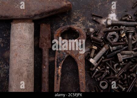 old nuts, screws and nails greasy and dirty heavily rusted lie on a metal dark background Stock Photo