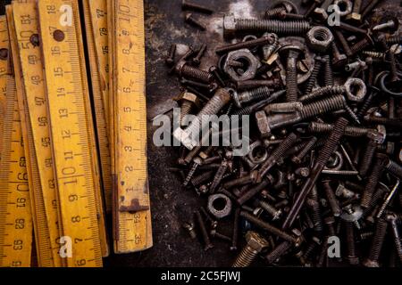 old nuts, screws and nails greasy and dirty heavily rusted lie on a metal dark background Stock Photo