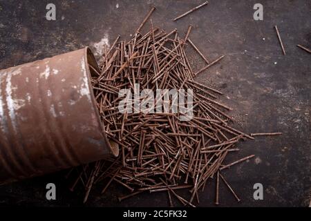 old tools hammer, pliers and nails heavily rusted lie on a metal dark background Stock Photo