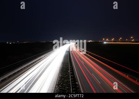 Highway light car trails leading from passing cars during night. Stock Photo