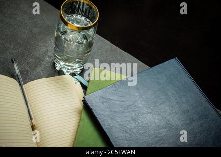 Books and a notebook with a pen on the desk Stock Photo