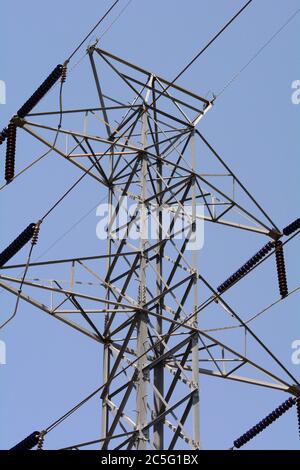 Closeup of electric power line pylon tower with insulators against clear blue sky Stock Photo