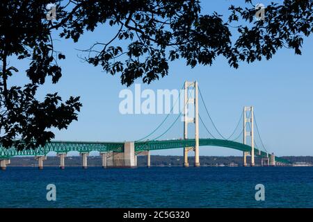 Oak leaves frame the Mackinac Bridge, a suspension bridge spanning the Straits of Mackinac to connect the Upper and Lower peninsulas of Michigan Stock Photo